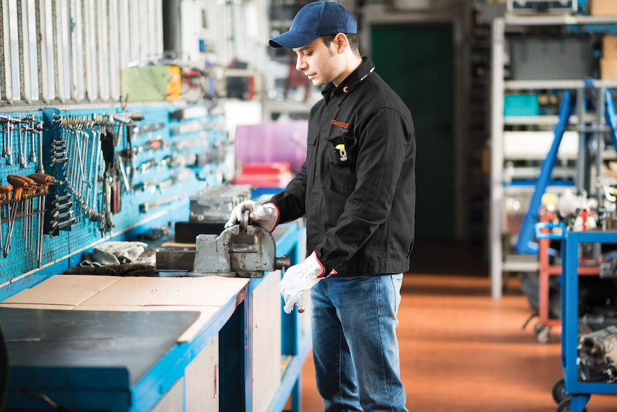 cleco care employee examines tools at work bench